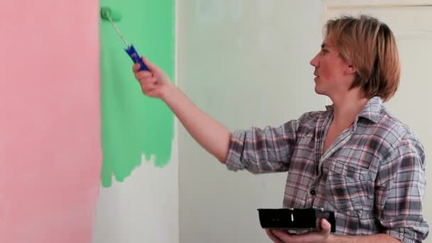 Muž maluje zdi v zeleným válečkem - Záběry, video