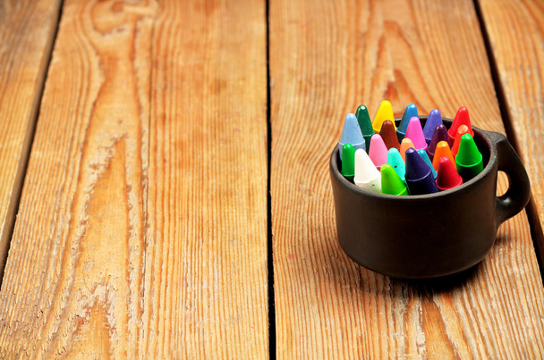 Краски в кружке на деревянном столе
 - Фото, изображение