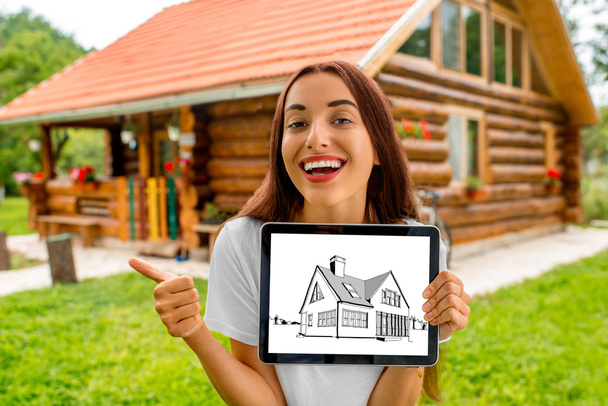 Vrouw weergegeven: digitale tablet met huis tekening - Foto, afbeelding