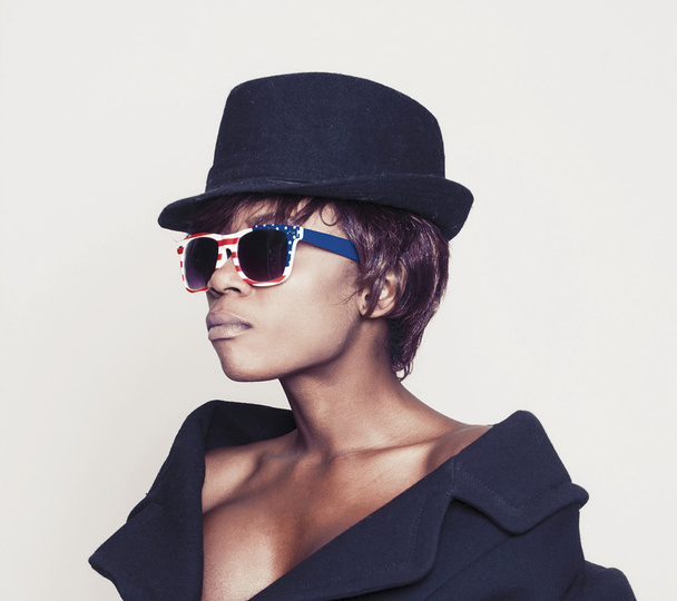Beautiful african model wearing coat, hat and american sunglasse - Zdjęcie, obraz