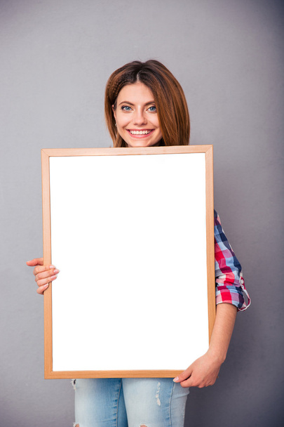 Mujer feliz sosteniendo tablero en blanco
 - Foto, Imagen