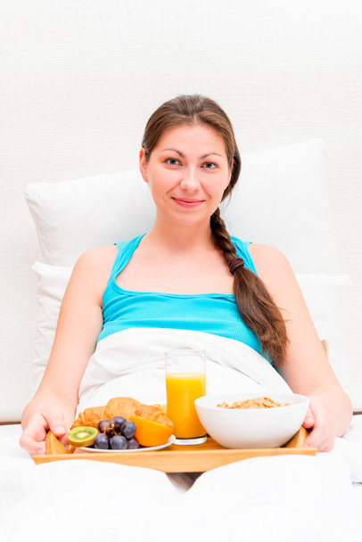 a woman with a tray of breakfast in bed in the morning - Foto, Imagem