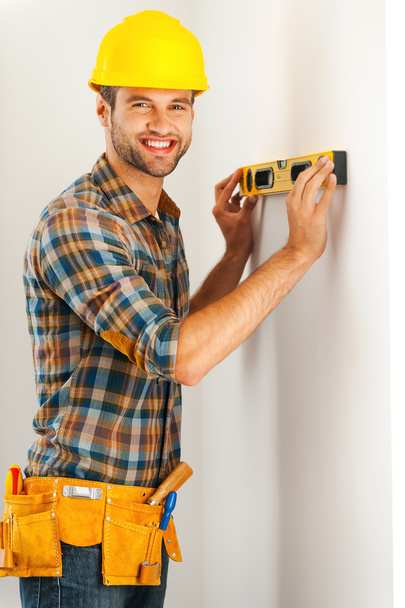 repairman making measurements on wall by level - Фото, изображение