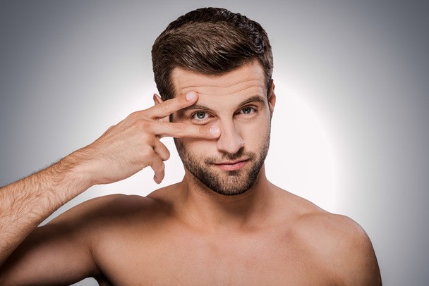 shirtless man holding fingers near his eye - Foto, Imagem