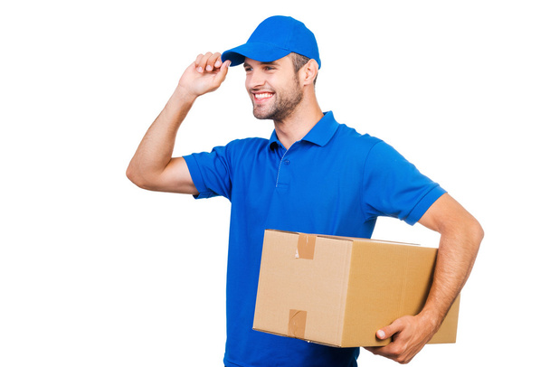 courier holding box and adjusting cap - Φωτογραφία, εικόνα