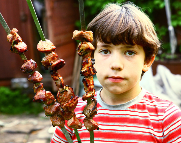 preteen przystojny chłopak z pieczonego mięsa na brochette pluć - Zdjęcie, obraz