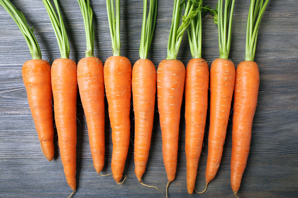 Fresh organic carrots on wooden table, closeup - 写真・画像
