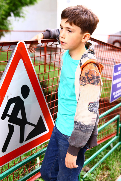 preadolescente guapo chico en la construcción frontera con advertencia sig
 - Foto, imagen