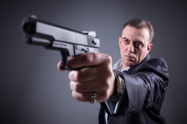 man in a business suit with a gun - Fotó, kép