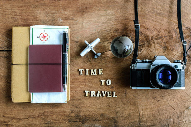 Notebook with map, passport and camera on wooden background - Фото, изображение