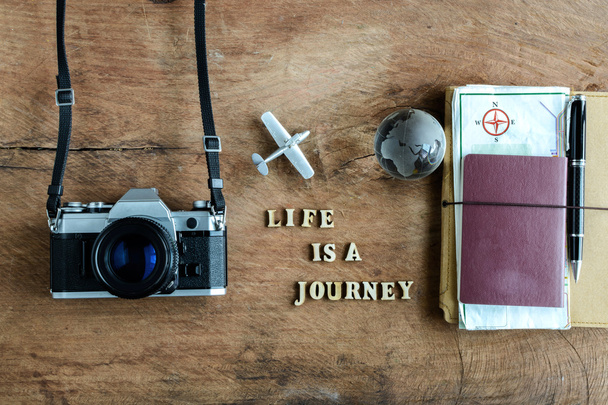 Notebook with map, passport and camera on wooden background  - Foto, afbeelding