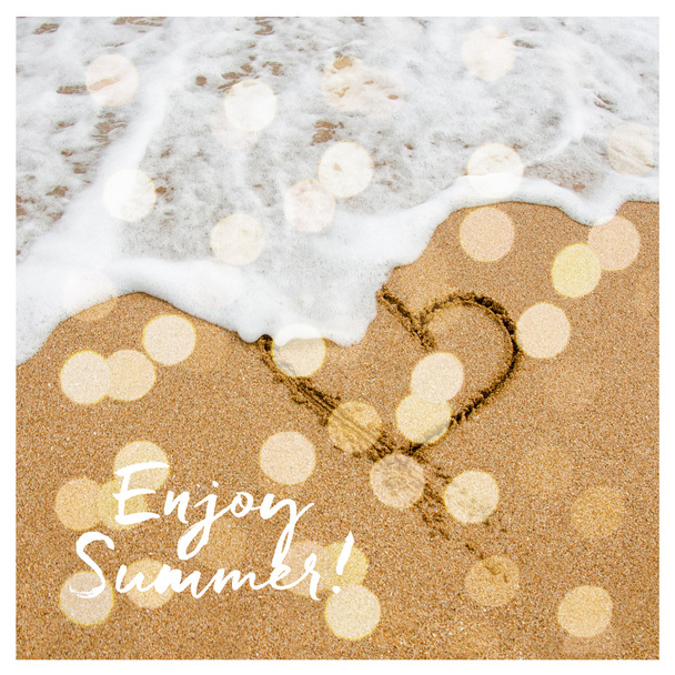 Enjoy summer card design with bokeh. Shape of the heart in the sand on the beach. - Foto, Bild