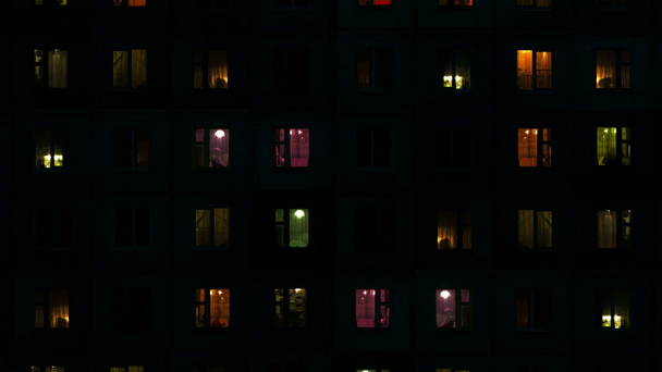 Licht in de ramen van het flatgebouw met hoge dichtheid 's nachts - Video