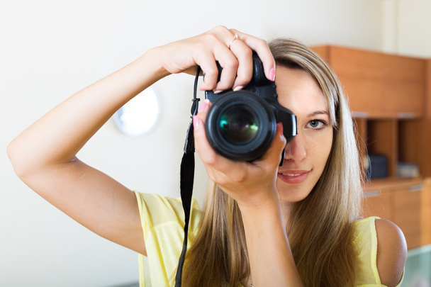 улыбающаяся девушка, работающая с фотокамерой
 - Фото, изображение