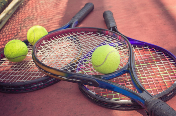 Raquette de tennis avec balles sur le court de tennis
 - Photo, image