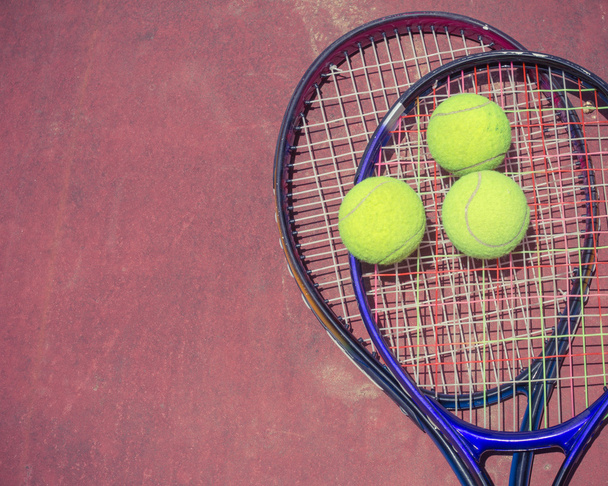 Tennisracket met ballen op de tennisbaan, vintage kleur - Foto, afbeelding