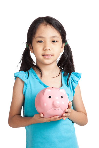 Little asian girl smile with piggy bank - Фото, изображение