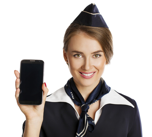 Happy young stewardess holding a smart phone isolated on white b - Foto, afbeelding