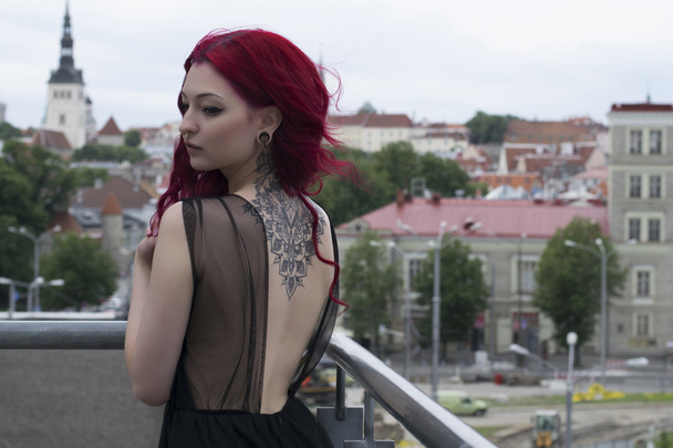 Redhead fashion model on parking balcony with city view background - Photo, Image