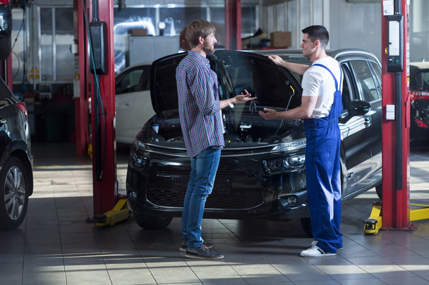 Automotive technician talking with client - Фото, изображение