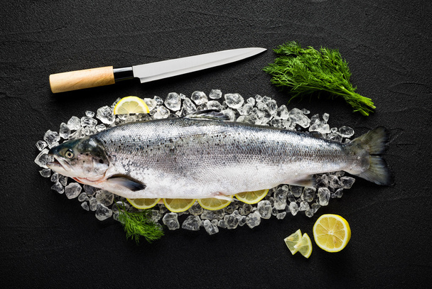 Peixe de salmão e ingredientes no gelo em uma mesa de pedra preta vi
 - Foto, Imagem