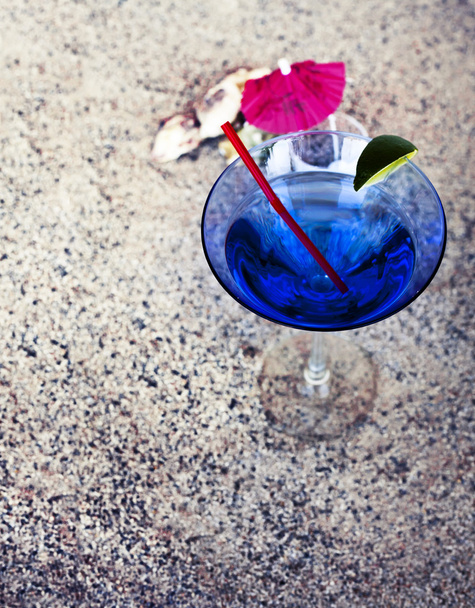 Achtergrond met cocktailglas met paraplu en een rietje - Foto, afbeelding