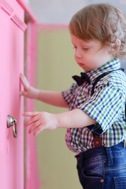Little dreaming boy opens pink door of cabinet - Photo, image