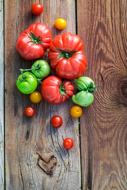 Healthy tomatoes on old wooden table - Valokuva, kuva