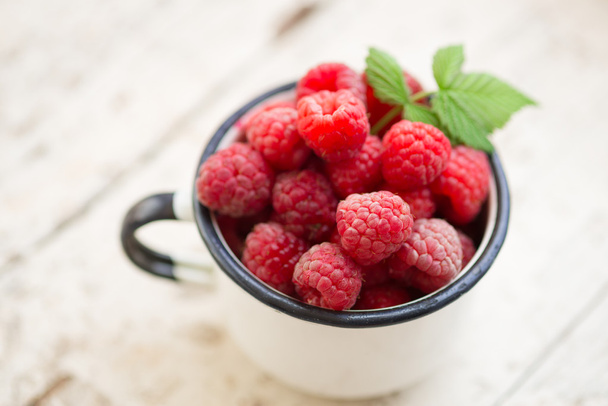 Raspberries in an enamel cup - Valokuva, kuva