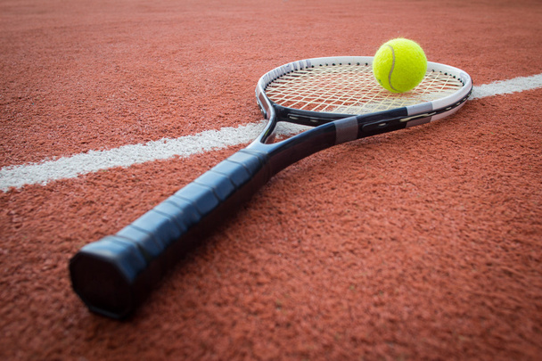 Теннисная ракетка и мяч на корте
 - Фото, изображение