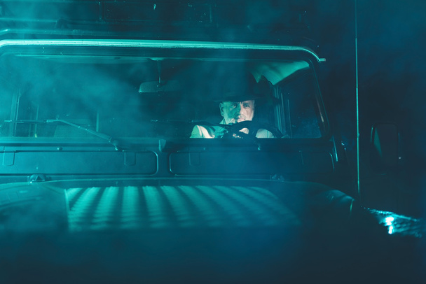 Homme mûr conduisant un véhicule la nuit
 - Photo, image