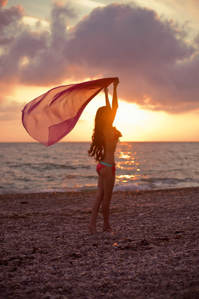Slim girl model enjoying sunset on the beach with beautiful sky. - Fotografie, Obrázek