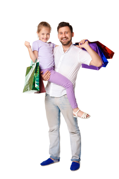Happy father and daughter with shopping bags standing at studio  - Foto, Imagem