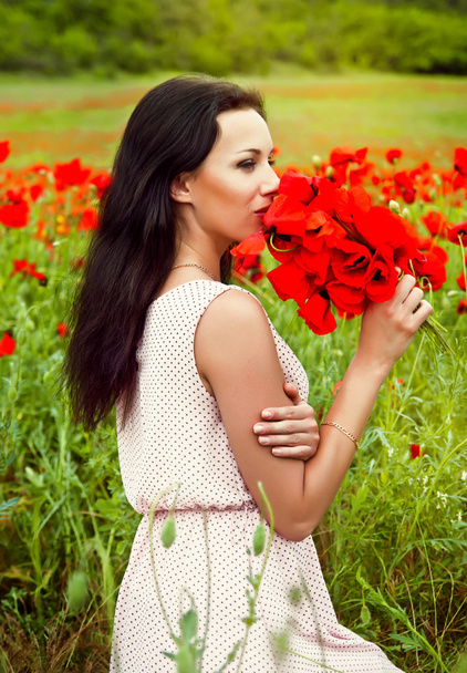 portrait of a beautiful woman in a field with flowers - Fotoğraf, Görsel