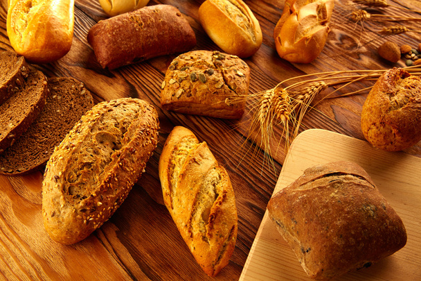 Bread varied mix on golden aged wood table - Foto, Imagen