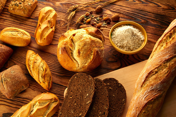 Bread varied mix on golden aged wood table - Foto, Imagen