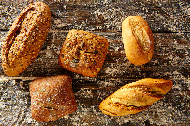 Pan de pan mezclado en una madera rústica y harina de trigo
 - Foto, Imagen