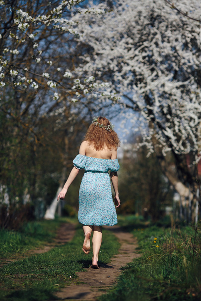 Beautiful girl follows a country road - 写真・画像
