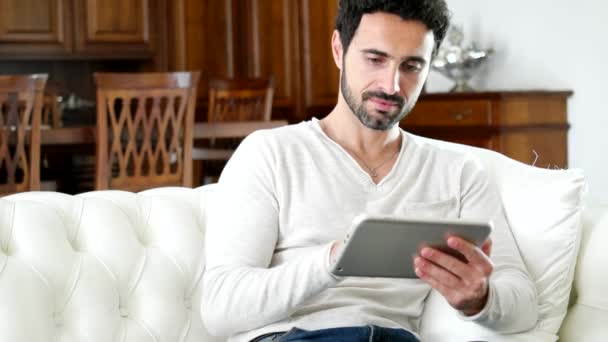 Man using tablet relaxing on sofa - Video