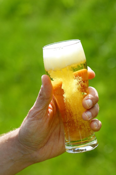 hand met bier - Foto, afbeelding
