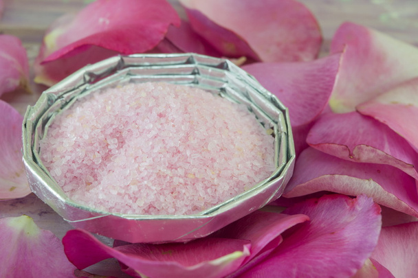 Vaaleanpunainen aromaattinen kylpy kulhossa suola pöydällä koristeltu ruusulla
 - Valokuva, kuva