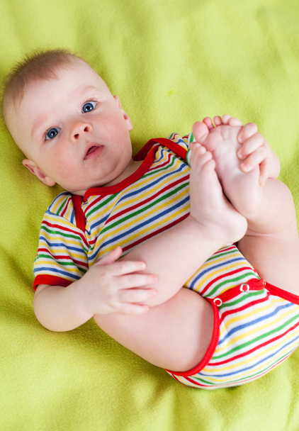 Cute boy holding his feet - Фото, изображение
