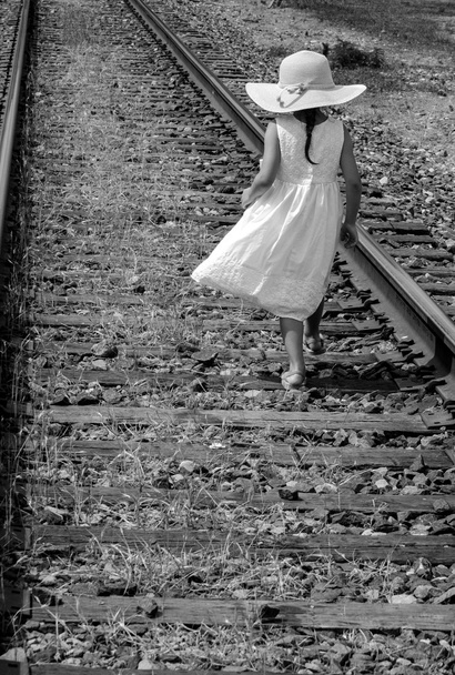 enfant rêveur en noir et blanc sur les voies ferrées
 - Photo, image