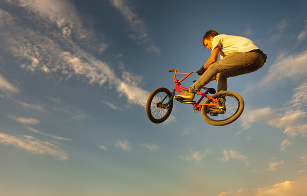 Un adolescente saltando en una bicicleta
. - Foto, imagen