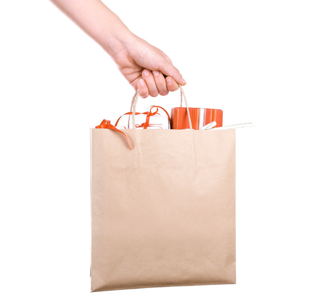 Female hand holding paper bag with present boxes isolated on white - Foto, afbeelding
