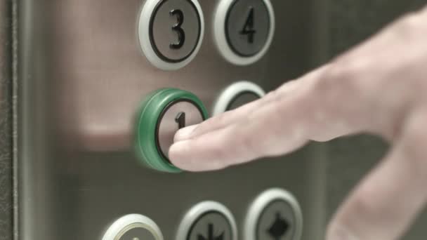 Mężczyzna naciska przycisk na pierwszym piętrze w windzie - Materiał filmowy, wideo