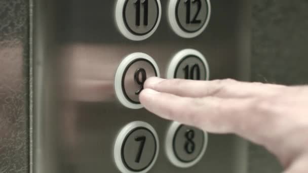 Άνθρωπος πατήσει το κουμπί για το ένατο όροφο σε ένα ασανσέρ - Πλάνα, βίντεο