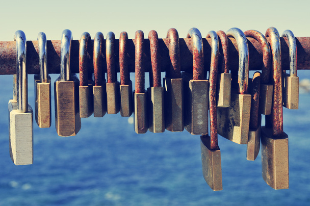 rusty padlocks on a railing near the sea - Fotó, kép