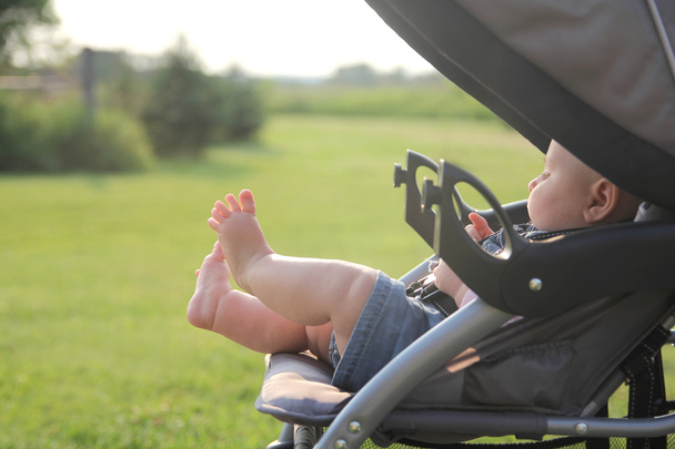 Pasgeboren Baby benen en voeten opknoping uit wandelwagen - Foto, afbeelding