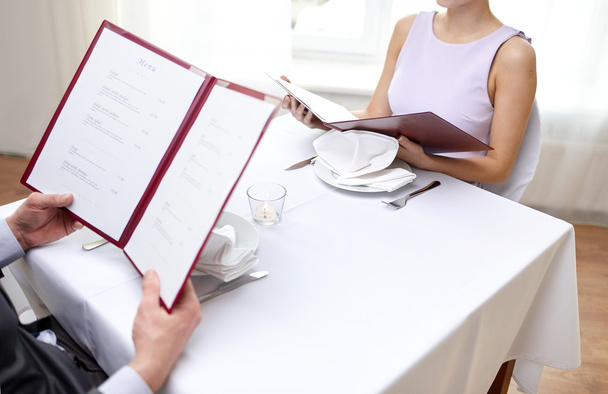 close up of couple with menu at restaurant - Foto, Imagen